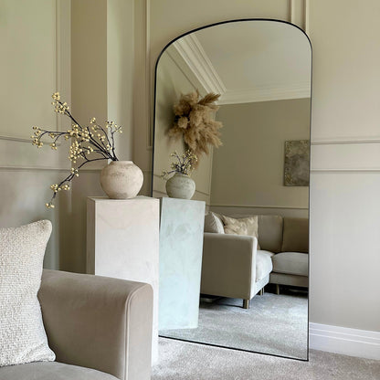 Full length black large metal mirror leaning against wall